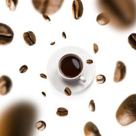 دانلود عکس فنجان قهوه و دانه های قهوه در حال پرواز در پس زمینه سفید