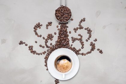 دانلود عکس فنجان قهوه سیاه با دانه های قهوه در پس زمینه سفید