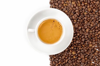 دانلود عکس فنجان قهوه در پس زمینه دانه ها و در نمای بالای سفید