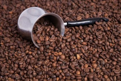 دانلود عکس فنجان قهوه روی پس زمینه دانه های قهوه
