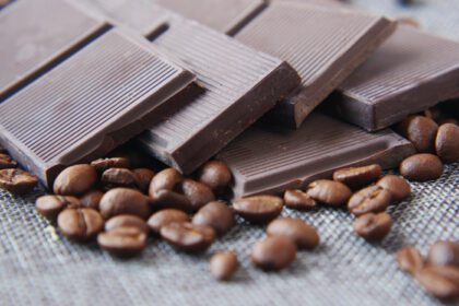 دانلود عکس شکلات تلخ و دانه های قهوه روی میز