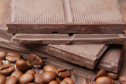 دانلود عکس شکلات تلخ و دانه های قهوه روی میز