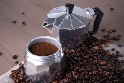 دانلود عکس قهوه ساز آبفشان جدا شده روی قهوه سطح چوبی