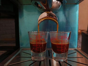 دانلود عکس چکیدن قهوه تازه در فنجان از قهوه ساز حرفه ای