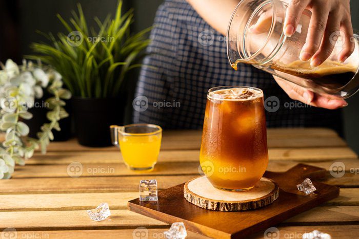 دانلود عکس لیوان اسپرسو با آب پرتقال روی میز چوبی و کپی
