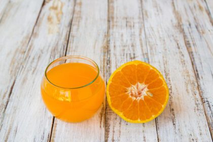 دانلود عکس لیوان آب پرتقال تازه پرس شده با خلال پرتقال