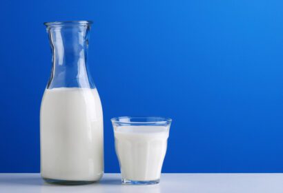 دانلود عکس لیوان شیر روی میز در مزرعه با دو بطری