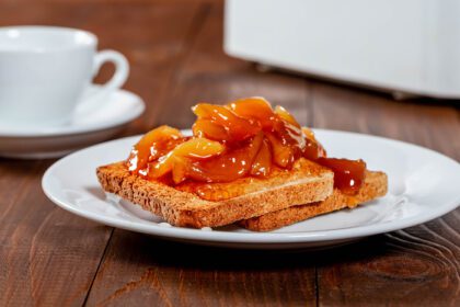 دانلود عکس توسکا سرخ شده با مربای هلو و یک فنجان چای برای صبحانه