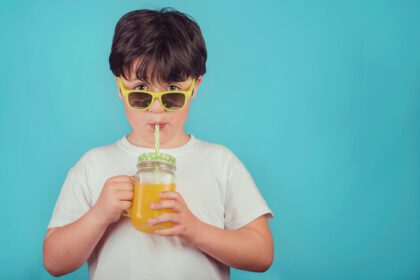 دانلود عکس پسر شاد در حال نوشیدن آب پرتقال