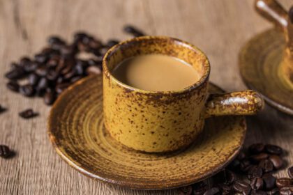 دانلود عکس قهوه داغ در فنجان قهوه ای در پس زمینه چوبی