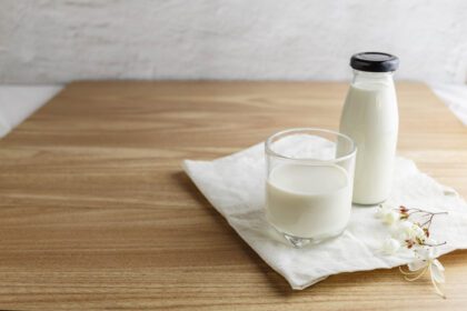دانلود عکس بطری شیر و لیوان شیر روی میز چوبی