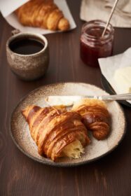 دانلود عکس صبحانه صبحانه با کروسان در بشقاب فنجان قهوه