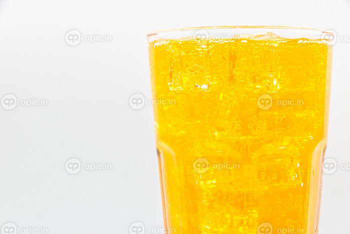 دانلود عکس آب گازدار نارنجی با یخ در شیشه روی پس زمینه سفید