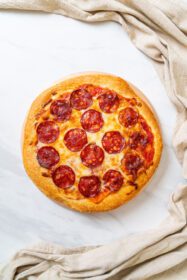 دانلود عکس پیتزا پپرونی روی سینی چوبی به سبک غذای ایتالیایی
