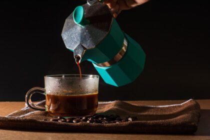 دانلود عکس ریختن قهوه سیاه داغ از موکا پات سبز تا قهوه شفاف