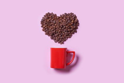 دانلود عکس فنجان قهوه قرمز و دانه قهوه خام به شکل قلب