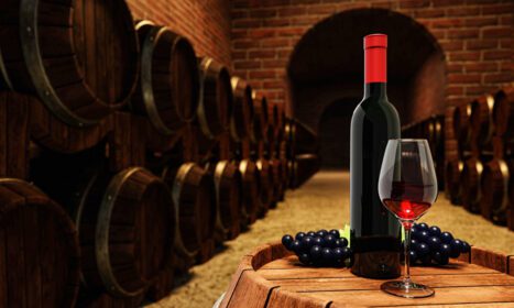 دانلود عکس بطری شراب قرمز و شیشه شفاف با شراب قرمز روی یک شراب