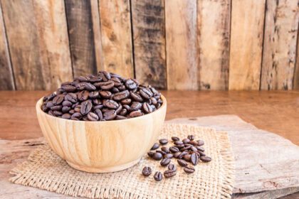 دانلود عکس دانه های قهوه بو داده در یک کاسه چوبی