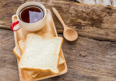 دانلود عکس تکه نان و قهوه در بشقاب چوبی