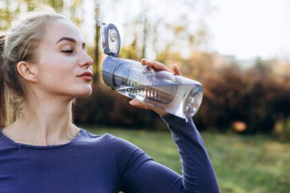 دانلود عکس دختر ورزشی لاغر در حال نوشیدن آب تناسب اندام زن جوان در حال گرفتن