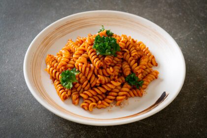 دانلود عکس پاستا مارپیچ یا اسپیرالی با سس گوجه فرنگی و سوسیس به سبک غذای ایتالیایی