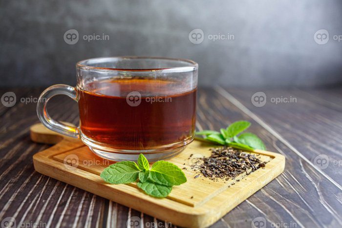 دانلود عکس چای در فنجان شیشه ای در پس زمینه چوبی