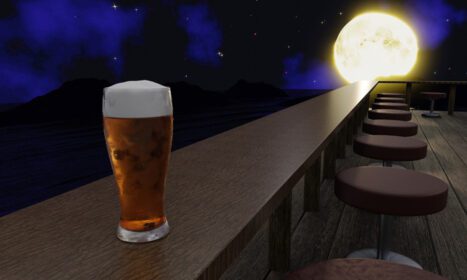 دانلود عکس آبجو در لیوان روی یک میز چوبی بلند قرار گرفته است