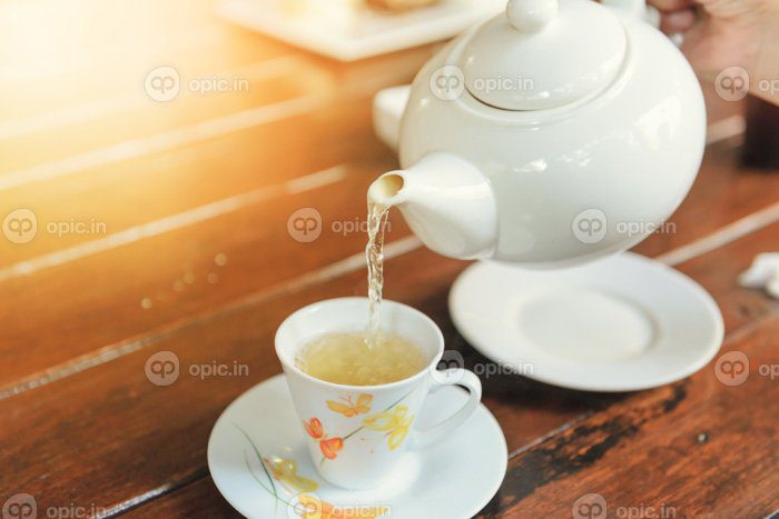 دانلود عکس زمان چای شکستن چای در حال ریختن از قوری در فنجان