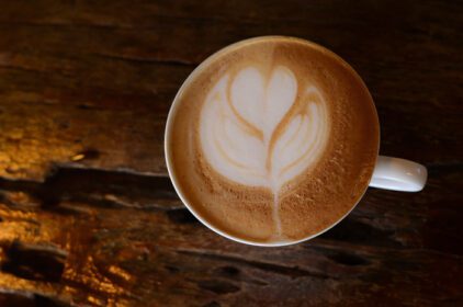 دانلود عکس نمای بالا از یک فنجان قهوه داغ کاپوچینو لاته آرت در