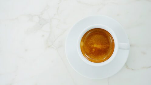 دانلود عکس نمای بالای قهوه اسپرسو داغ در لیوان سفید روی سنگ مرمر سفید