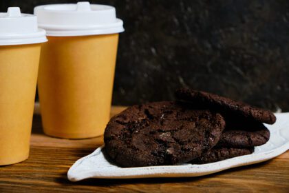 دانلود عکس دو لیوان قهوه آماده و یک کوکی آمریکایی در تاریکی