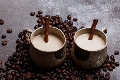 دانلود عکس دو فنجان قهوه با دانه های قهوه در پس زمینه ای تاریک