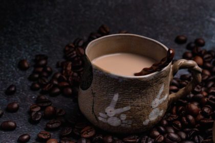 دانلود عکس دو فنجان قهوه با دانه های قهوه در پس زمینه ای تاریک