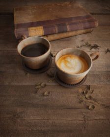 دانلود عکس دو فنجان قهوه قدیمی روی میز چوبی با کتاب های قدیمی سه بعدی