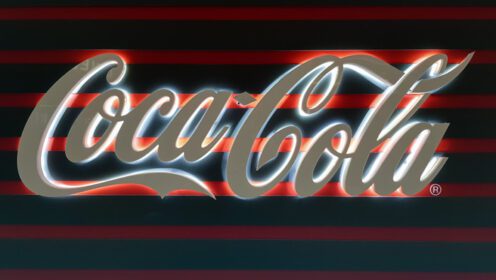 دانلود عکس نمای یک علامت کوکاکولا سفید درخشان در کوکای تاریک
