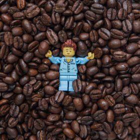 دانلود عکس مینی فیگور لگو ورشو که در دانه های قهوه خوابیده است