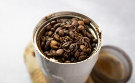 دانلود عکس دانه های کامل قهوه در یک آسیاب قهوه برقی