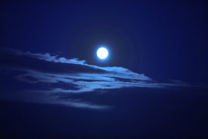 دانلود عکس یک ماه بزرگ زیبا در آسمان آبی تیره با ابرها