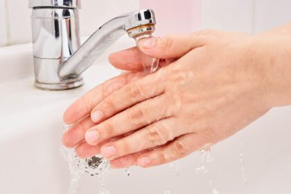 دانلود عکس زن در حال شستن دست هایش زیر آب گرم