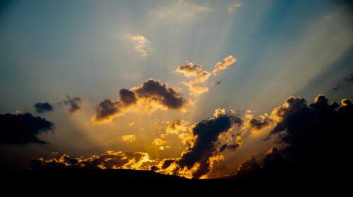 دانلود عکس پرتوی از نور خورشید کوه و ابرها را به رنگ آبی می شکند