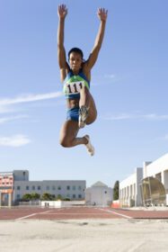 دانلود عکس ورزشکار زن آفریقایی در هوا در حین پرش طول