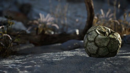 دانلود عکس یک توپ فوتبال قدیمی پاره شده پرتاب شده روی شن های ساحل دریا