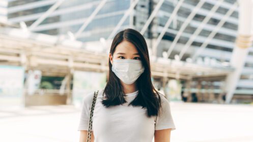 دانلود عکس یک زن آسیایی تجاری بزرگسال برای محافظت از ویروس ماسک صورت می پوشد