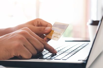 دانلود عکس تاجر دست در دست گرفتن کارت اعتباری با استفاده از لپ تاپ برای