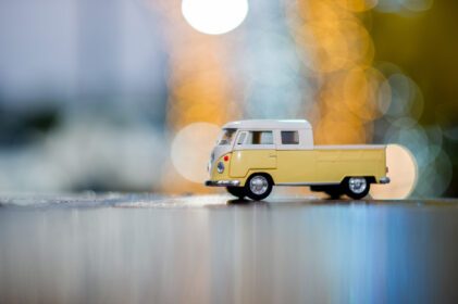 دانلود عکس ماشین های اسباب بازی زرد کلاسیک پارک شده در کف چوبی و دارای