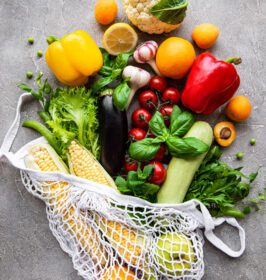 دانلود عکس سبزیجات و میوه های تازه روی کیسه رشته ای اکو روی بتن