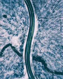 دانلود عکس نمای هوایی از بالا به پایین جاده ای در میان زمین پوشیده از برف