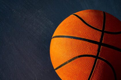 دانلود عکس توپ بسکتبال روشن شده توسط نور خورشید در تاریکی