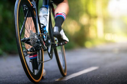 دانلود عکس ورزشکار دوچرخه سواری آماده برای دوچرخه سواری در جاده خیابان