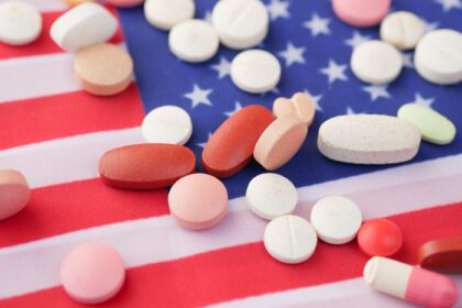 دانلود عکس ریختن قرص های پزشکی رنگ سفید روی پرچم آمریکا